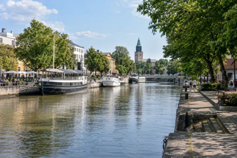 AI ilustrace: řeka a zelené nábřeží inspirované Turku.